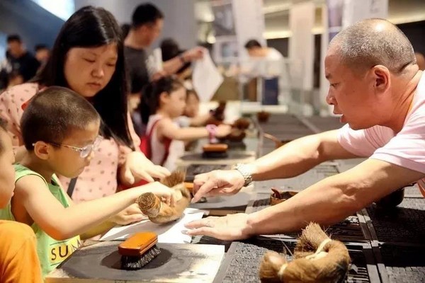 图7 我国近年来通过多种方式开展非物质文化遗产的弘扬、传播工作,图为小朋友在非物质文化遗产主题展览中体验中国活字印刷术.jpg