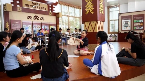 图4 海南省白沙县开展的黎族传统纺染织秀技艺进校园活动,省级代表性传承人符秀英向学生讲解绣法.jpg